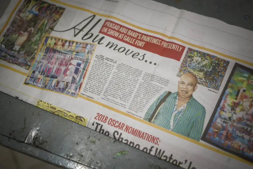 A newspaper is spread out on the floor, showcasing its headlines and articles