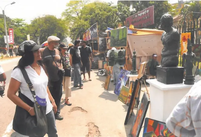 A bustling outdoor market filled with people shopping for fresh produce and various goods.