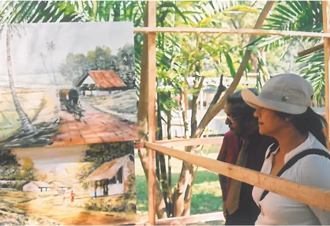 Two individuals examining artwork displayed on a wooden frame in a gallery setting.