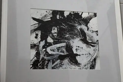 A framed black and white painting depicting a bird, showcasing intricate details and elegant lines.