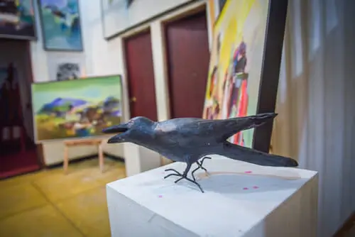 A bird sculpture elegantly displayed in an art gallery, showcasing intricate details and artistic craftsmanship.