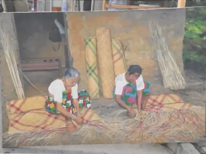 A painting depicting two women skillfully crafting mat, showcasing their artistry and dedication to traditional craftsmanship