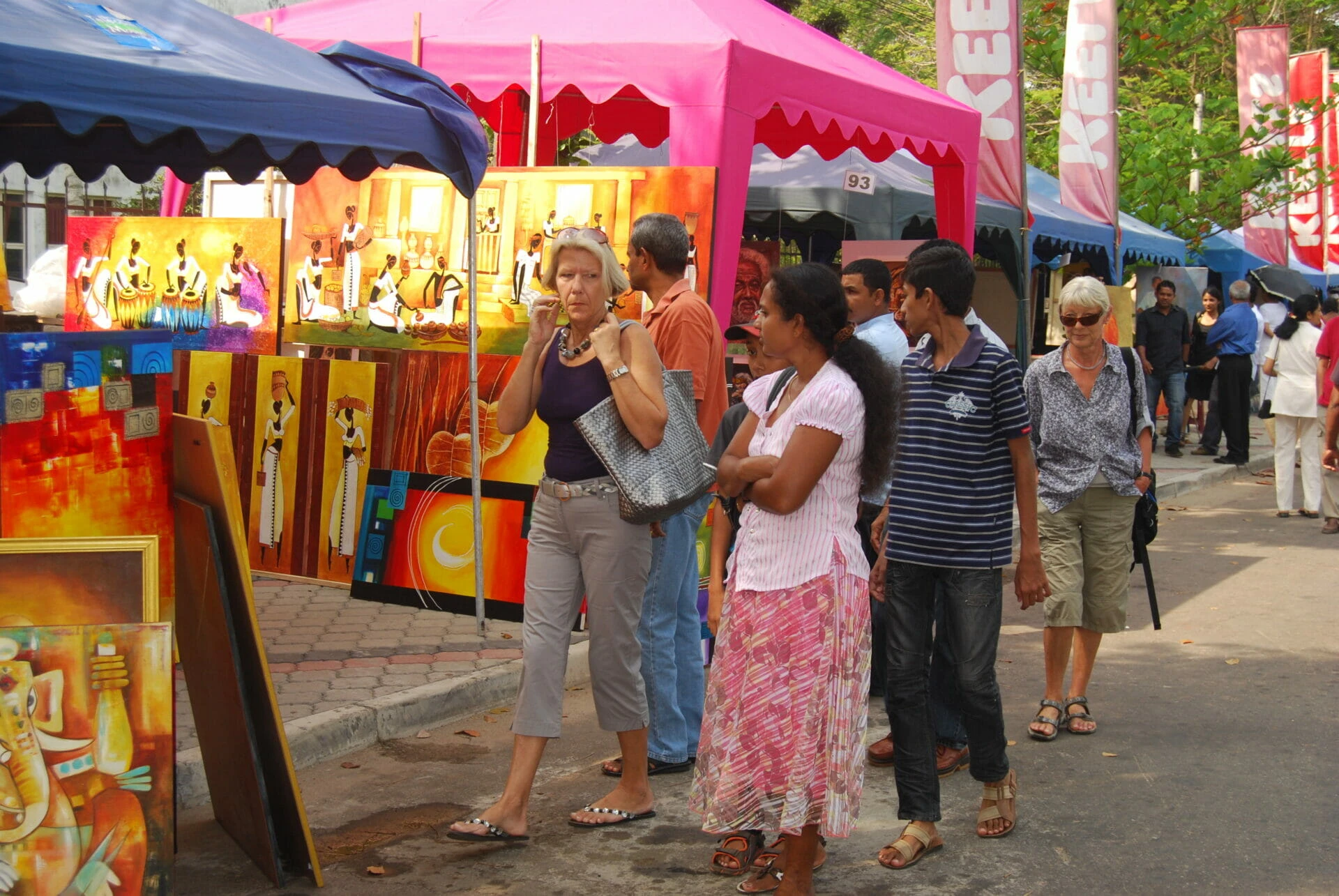 A diverse group of individuals walking along a bustling city street, engaged in conversation and enjoying the day.