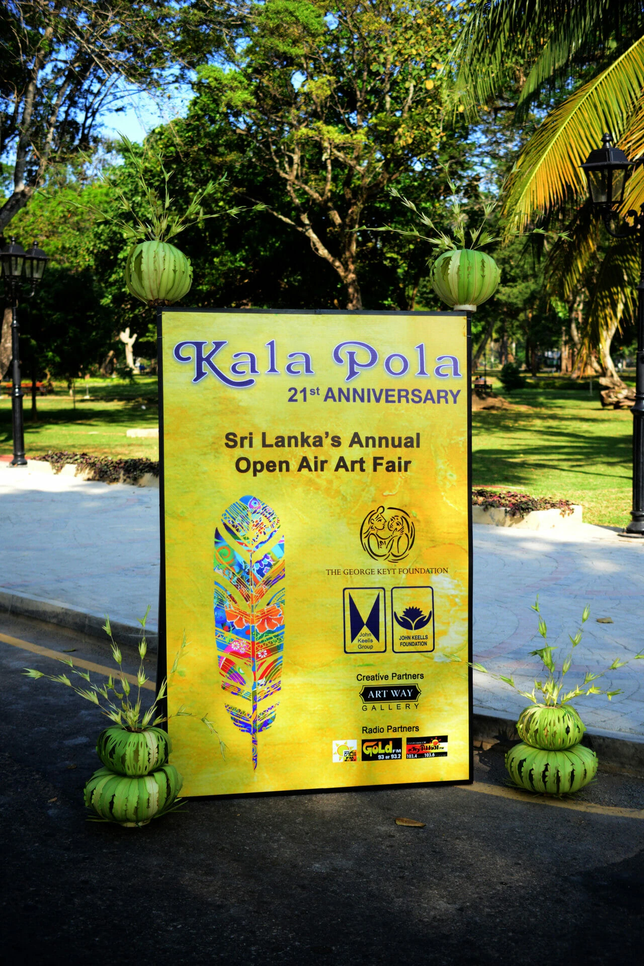 A lime-colored banner featuring a some logos, arts and text celebrating a 21st anniversary event.