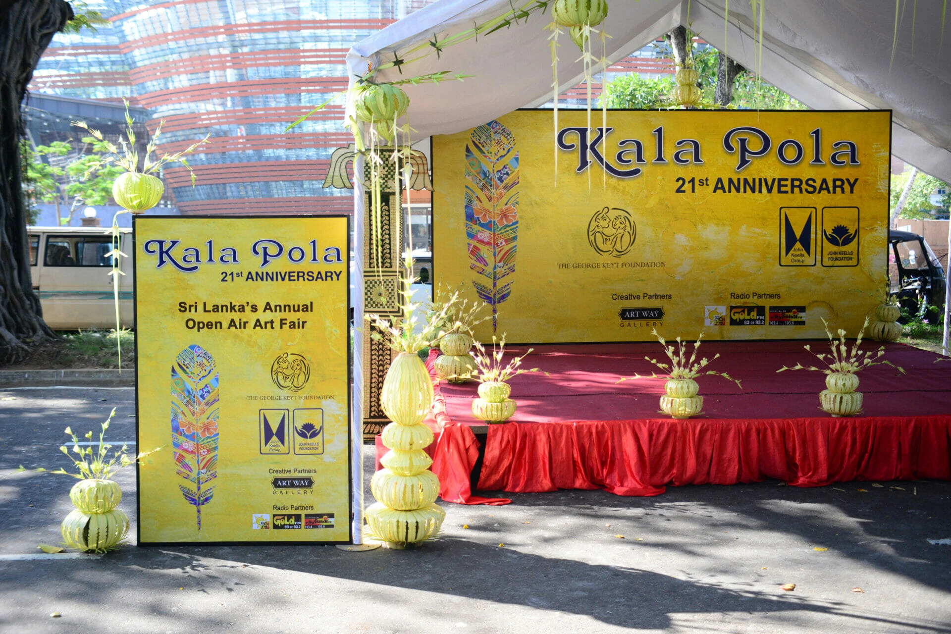 A lime-colored banner featuring a some logos, arts and text celebrating a 21st anniversary event.