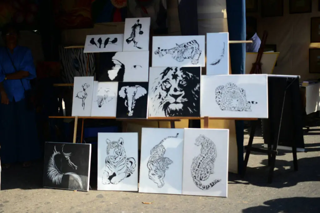 A table displaying numerous black and white paintings arranged artistically.