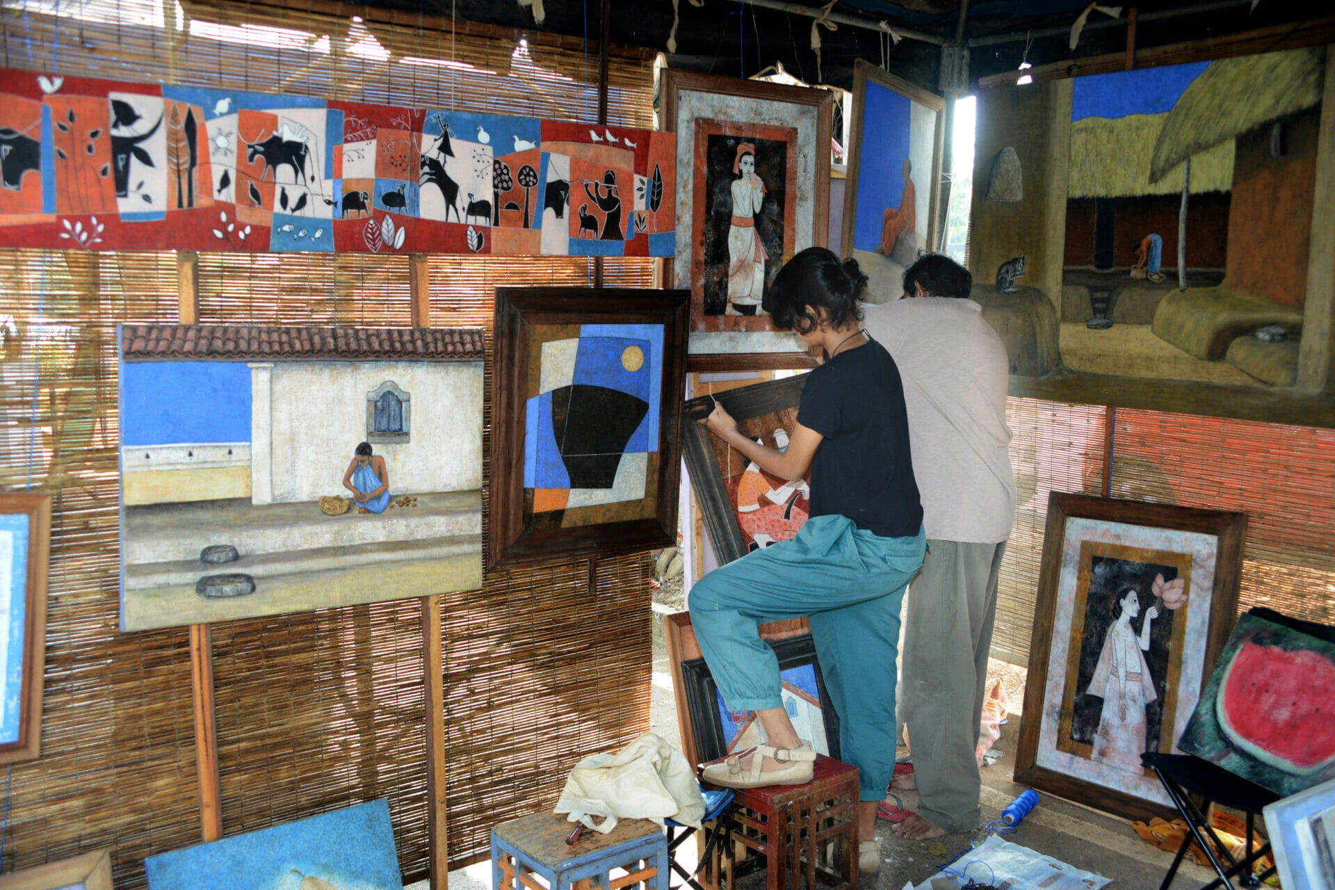 An artist diligently painting on a canvas, showcasing creativity and concentration in a well-lit workspace.