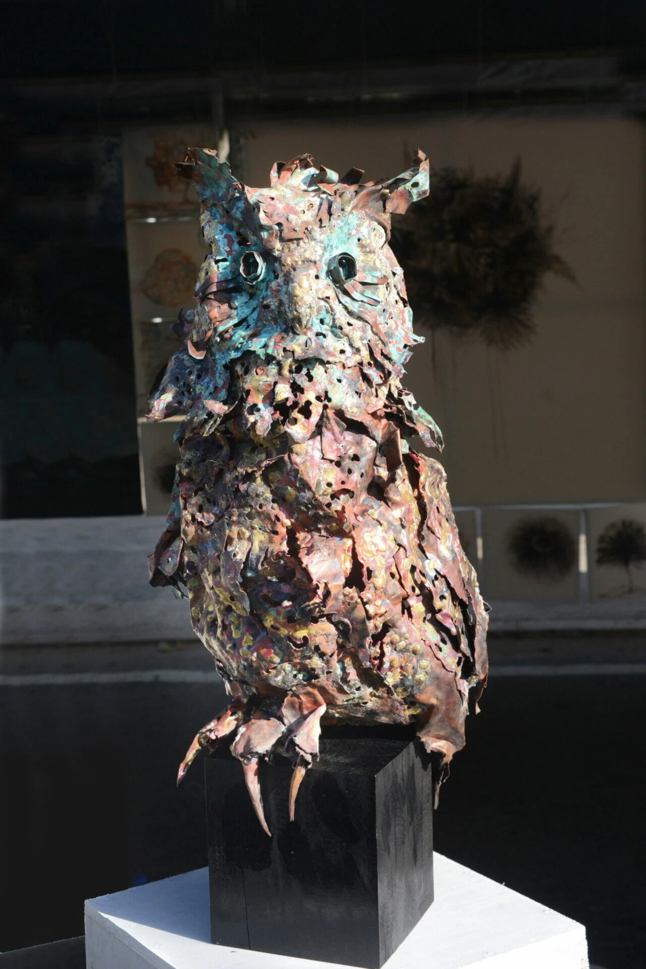 A detailed sculpture of an owl perched gracefully on a pedestal, showcasing intricate craftsmanship and artistry.