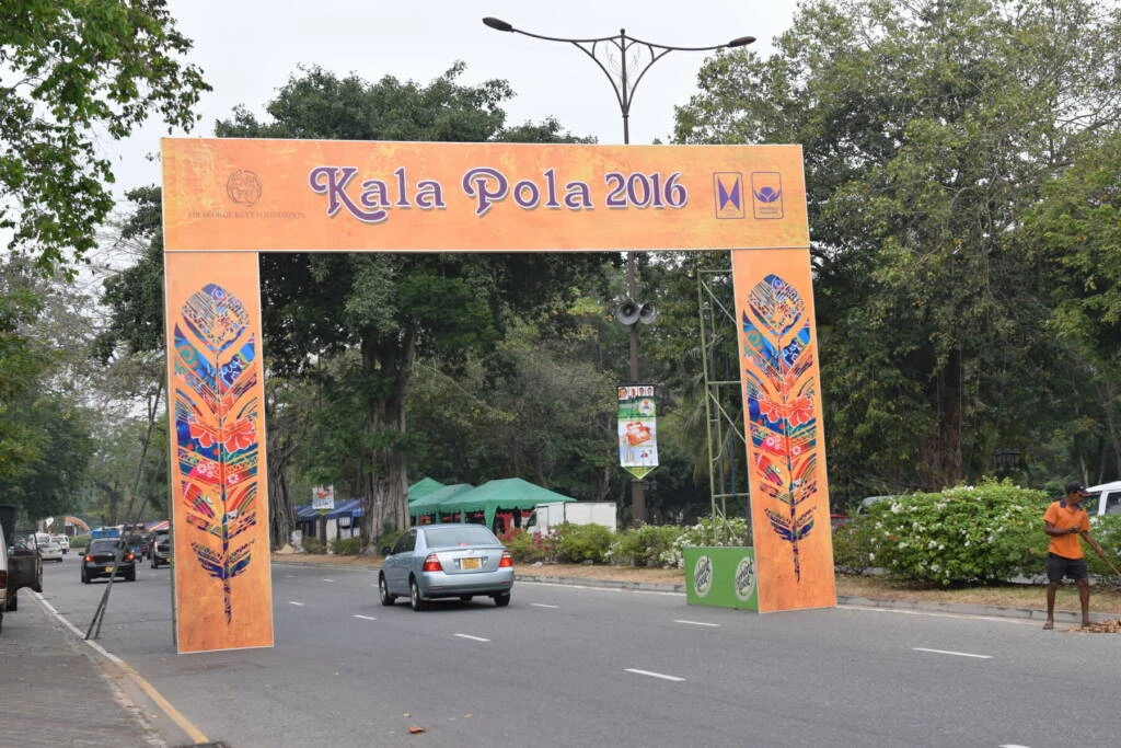 A lively street showcasing a prominent sign that says "kala pola," embellished with playful, child-drawn artwork.