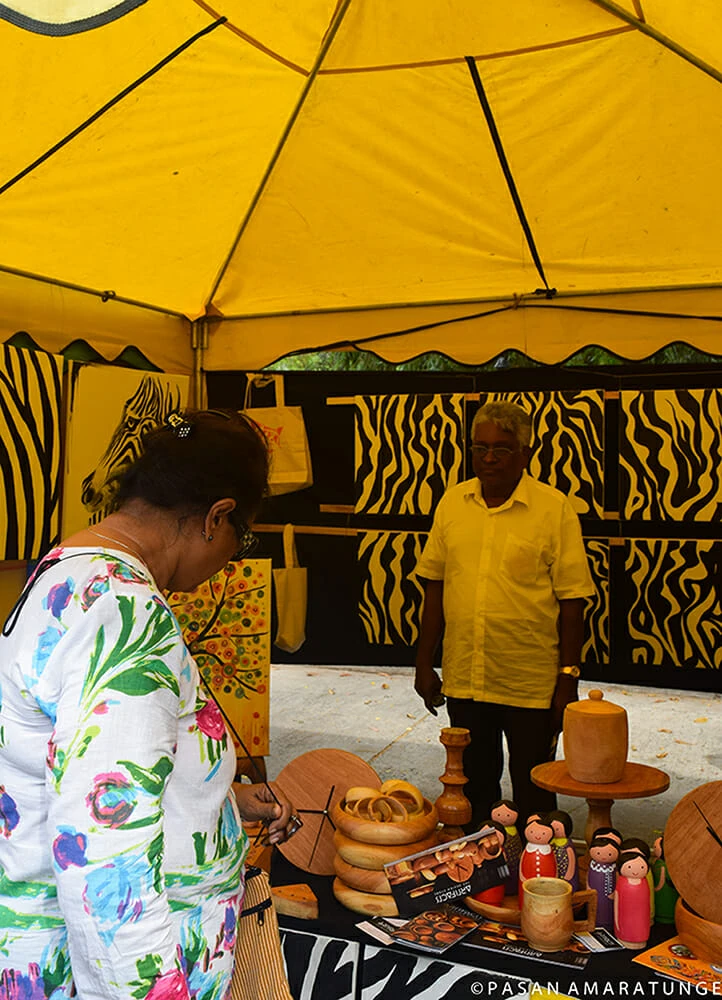 A woman examines a variety of pottery displayed on a shelf, showcasing her interest in the artistic craftsmanship.