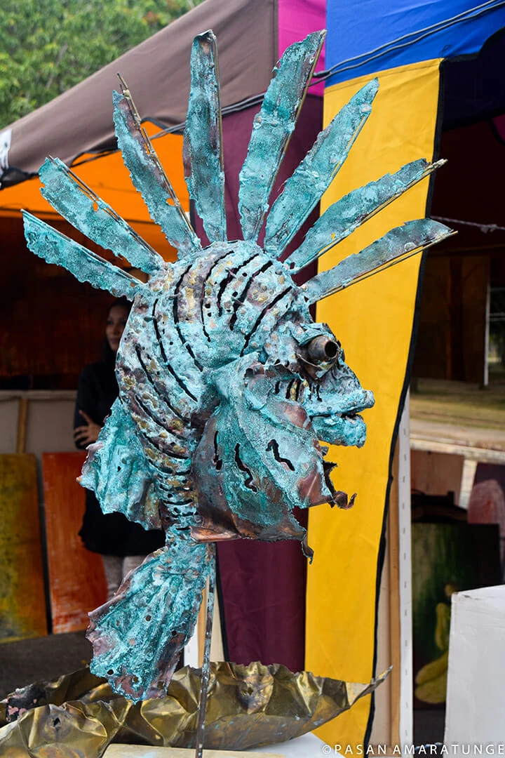 A detailed sculpture of a fish head showcased prominently at a bustling market, highlighting its artistic craftsmanship.