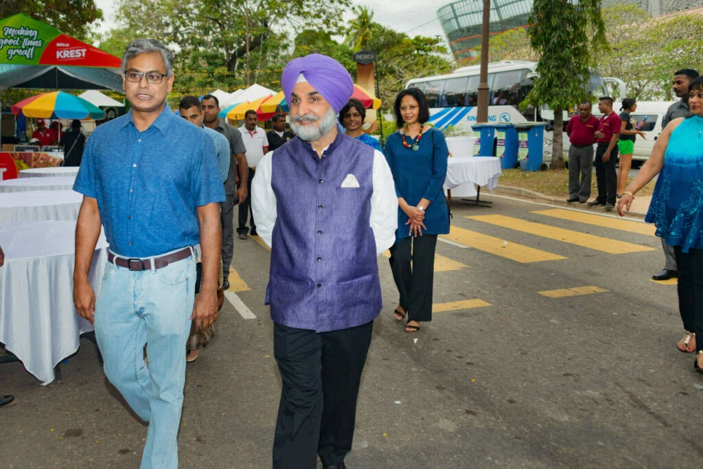 A man strolls down the street alongside another man who is wearing a turban, showcasing a moment of cultural diversity.