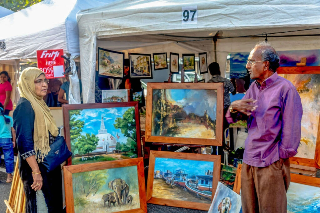 Two women engaged in painting together, demonstrating teamwork and artistic expression on a shared canvas.