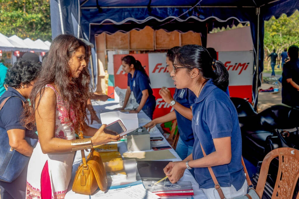 Artists showcase and sell their paintings at a vibrant street fair, engaging with visitors and promoting their artwork.
