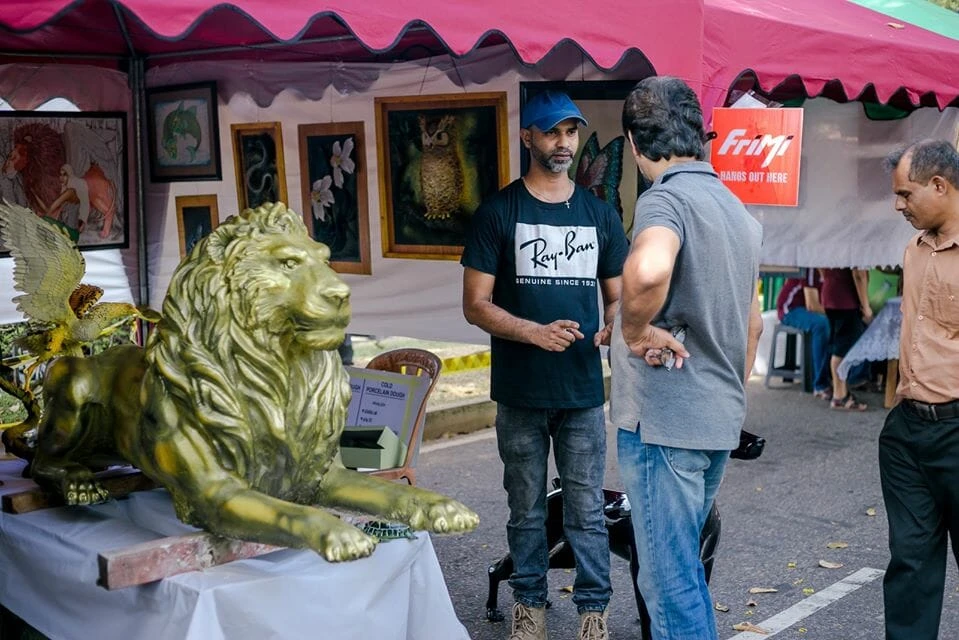A group of men wearing blue shirts and hats gathered together, engaged in conversation outdoors.