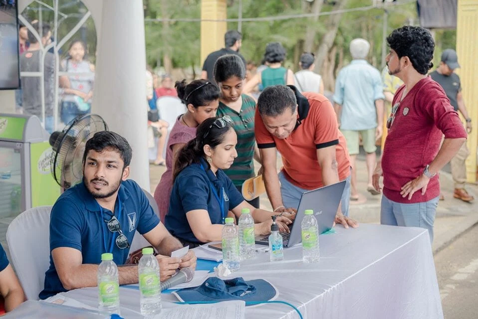 Shoppers explore an outdoor market filled with an array of wooden products, creating a lively atmosphere.