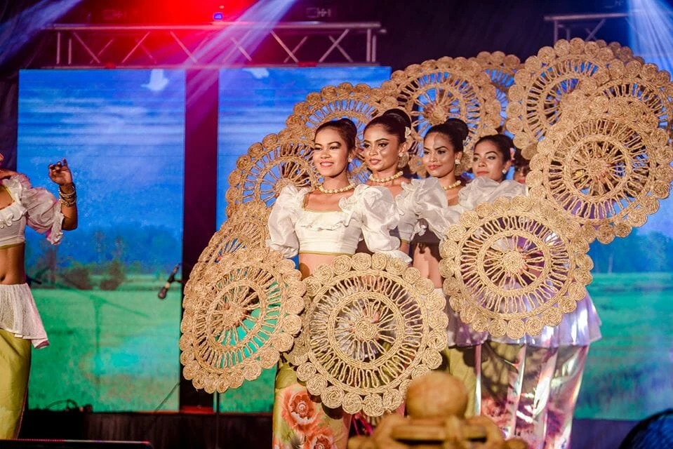 Two men walk amidst a crowded market, engaging with the vibrant atmosphere and numerous shoppers.