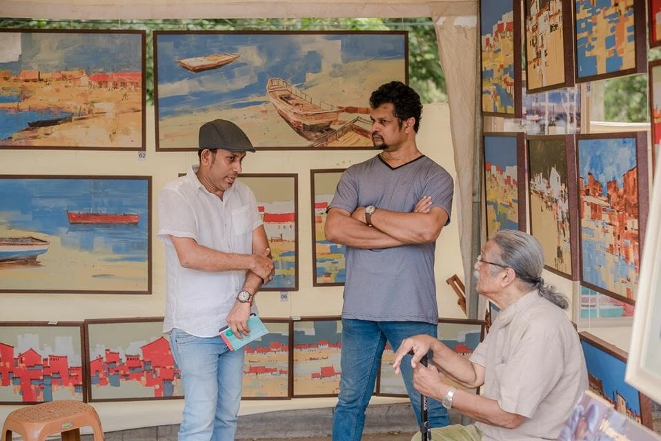 A diverse group of individuals collaborating at a table, each focused on their laptops, engaged in productive discussion.