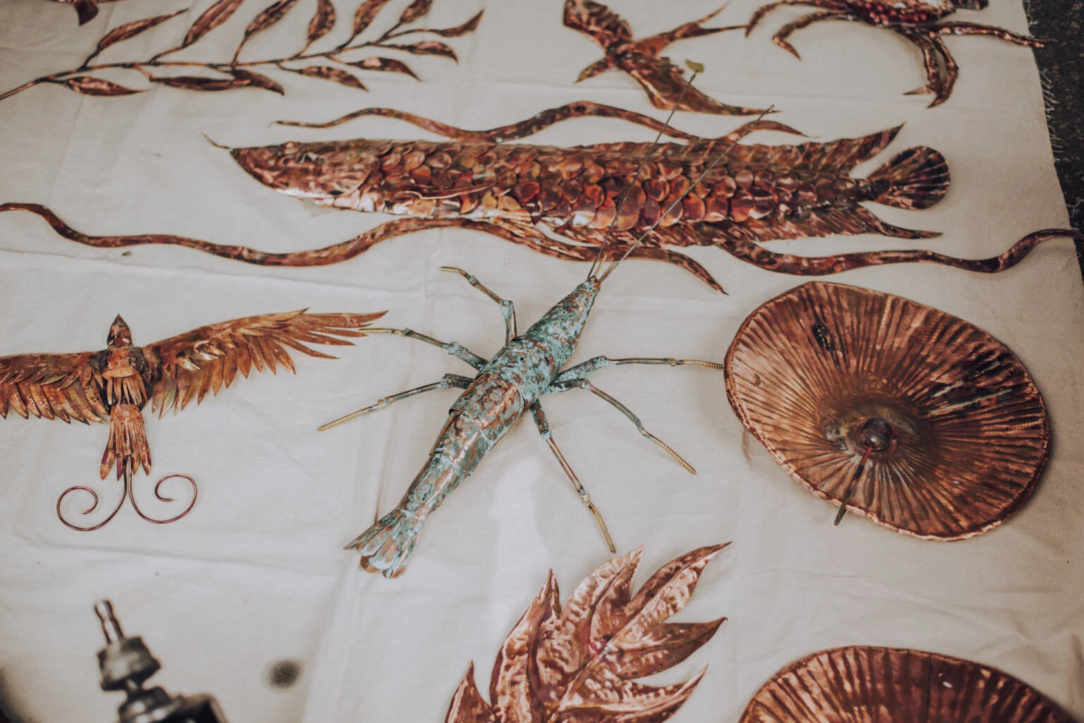 A table displaying an assortment of intricate metal sculptures, showcasing diverse artistic designs and craftsmanship.