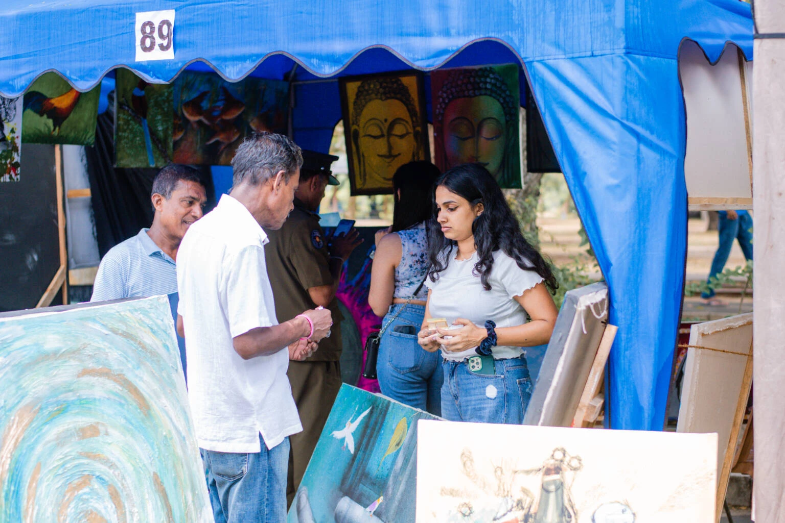 A man and woman stand together in front of a tent, smiling and enjoying the outdoor setting.