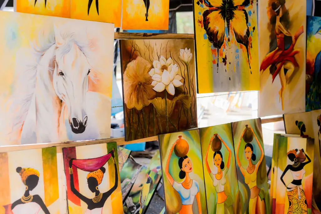 A woman engaged in painting a horse, with vibrant colors and brushes scattered around her in a creative workspace.