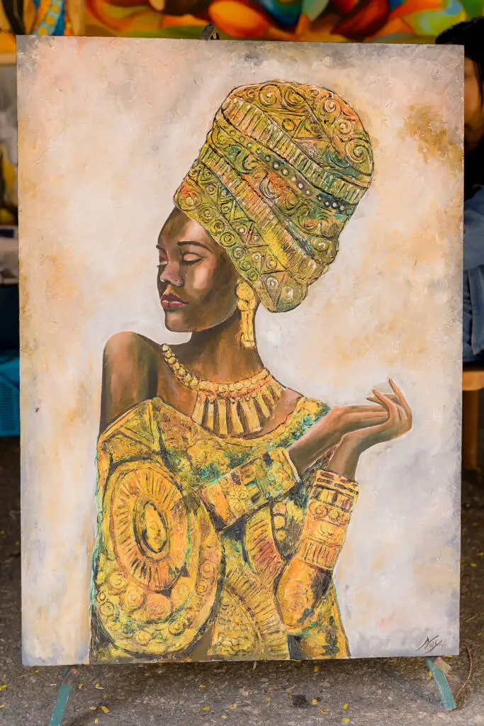 An African woman skillfully painting on a canvas, showcasing her artistic talent and cultural expression.