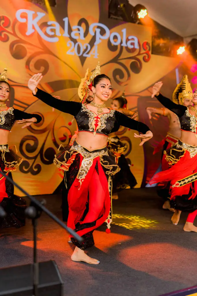 A diverse group of women joyfully performing a synchronized dance in a vibrant setting.