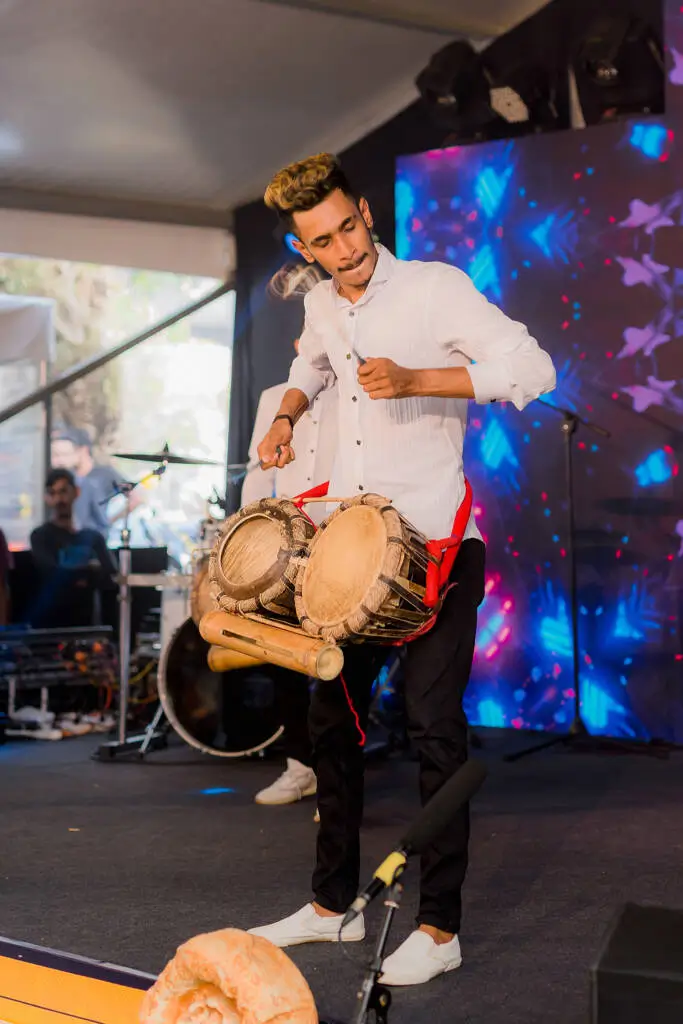A man energetically playing drums, showcasing his passion for music and rhythm.