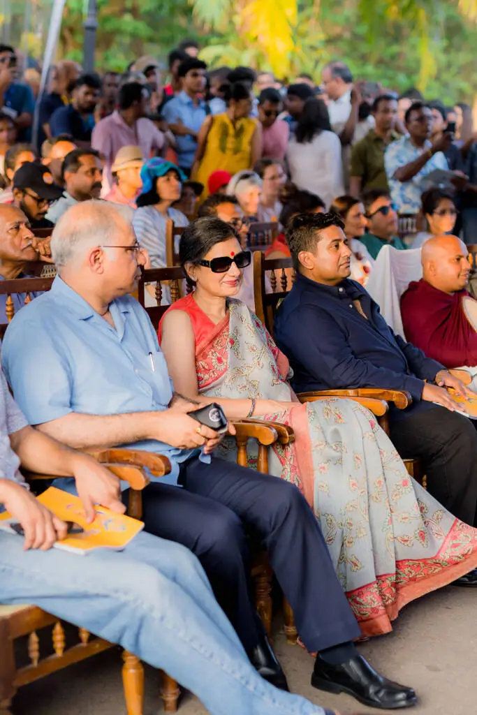 A diverse group of individuals seated in chairs, engaged in conversation and sharing ideas in a collaborative setting.