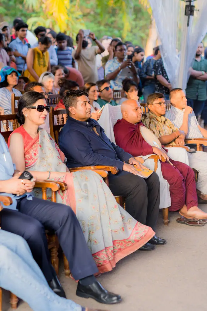 A diverse group of individuals seated in chairs, enjoying an outdoor event.