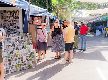 A group of people standing in line, demonstrating a mix of ages and backgrounds in a bustling environment.
